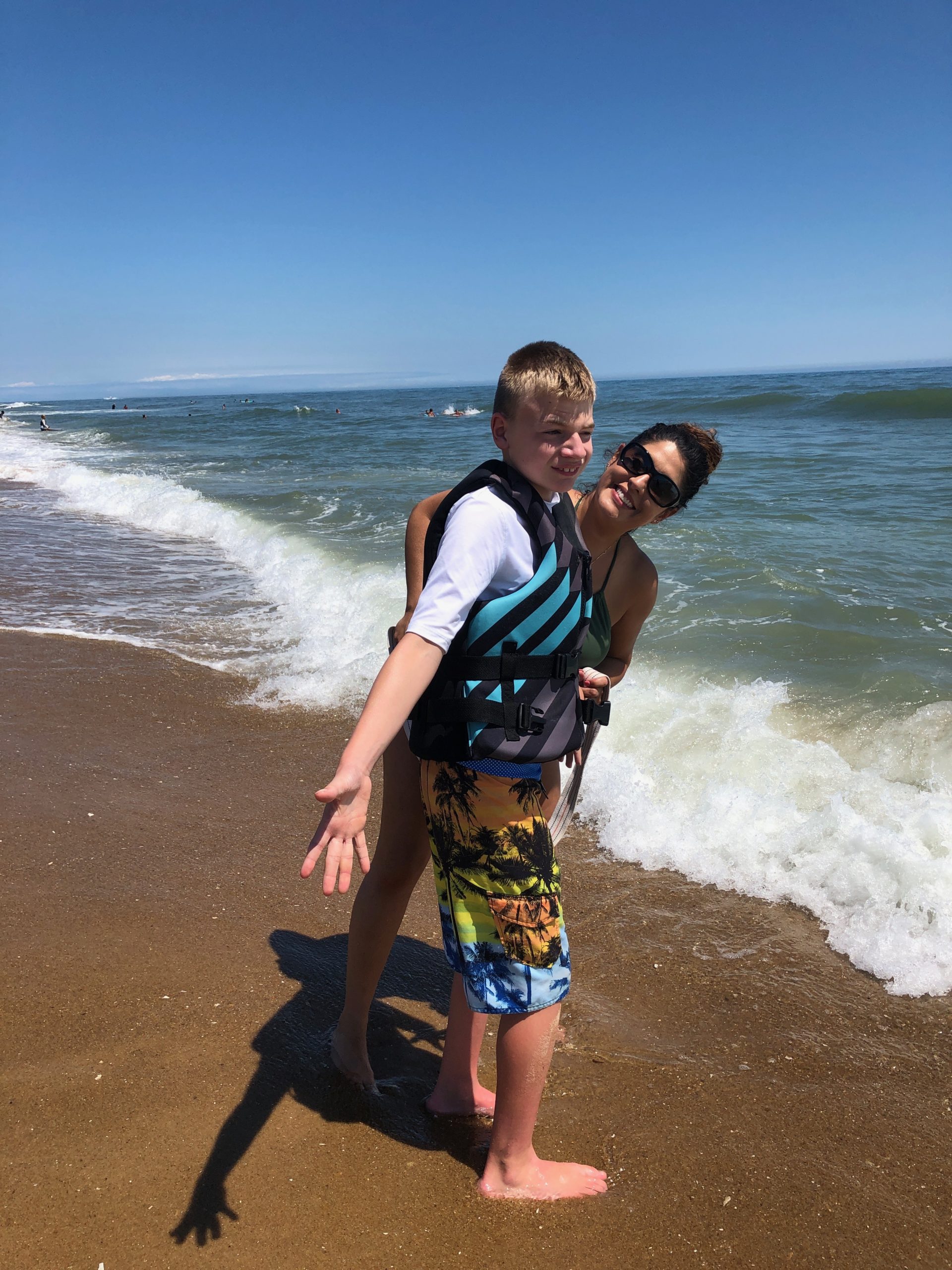 boy and direct care worker at the beach